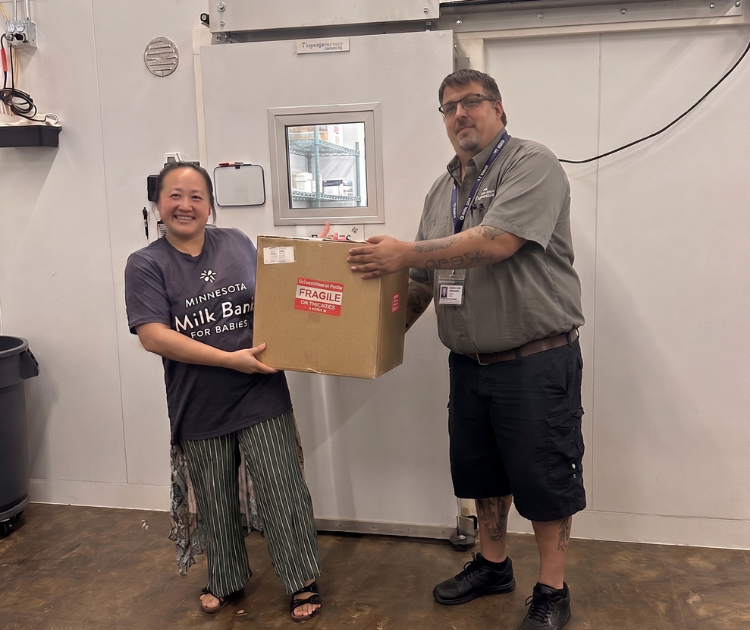 Mellisa of the Minnesota Milk Bank for Babies with Quicksilver driver Tim holding a box